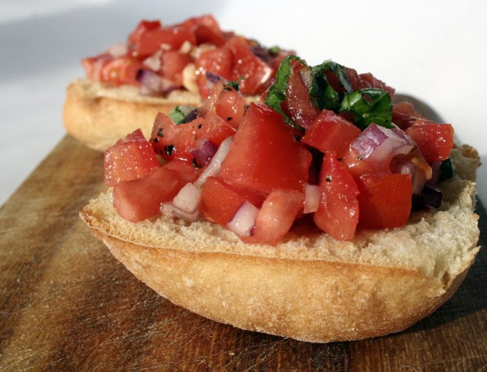Chopped tomatoes and herb, onion salsaon teo pieces of bread on wooden board