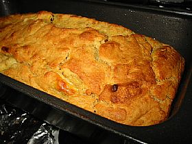 A Baked golden brown loaf in baking tin