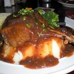 Rack of lamb on mashed potatoes with gravy and fresh herbs