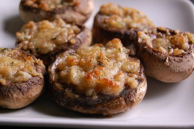 Several mushrooms topped with filling and baked on a plate