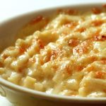 Saucy macaroni cheese in a creamy coloured round bowl.