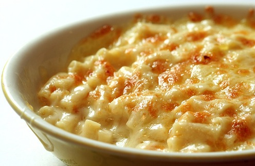 Saucy macaroni cheese in a creamy coloured round bowl.