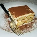 layered dessert tiramisu on a plate with a fork
