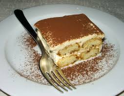 layered dessert tiramisu on a plate with a fork