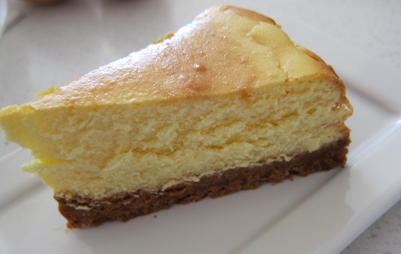 A slice of baked cheesecake on a plate