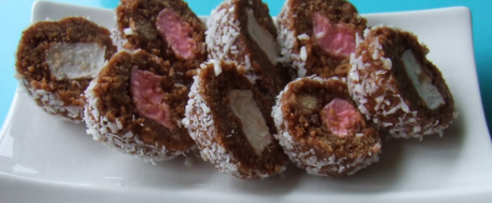 Several halves of chocolate balls with white and pink centre showing.