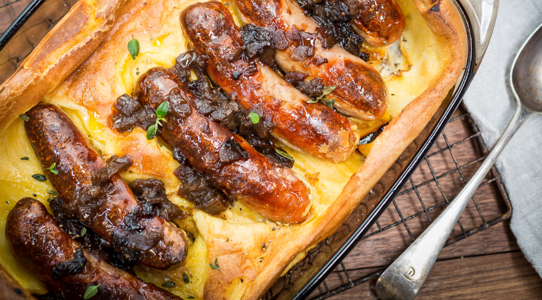 four Baked sausages in yellow bread.