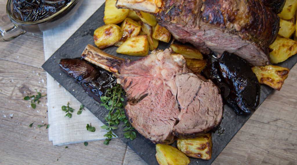 Whole rack of beef rib roasted and a few sliced with potatoes and herb,