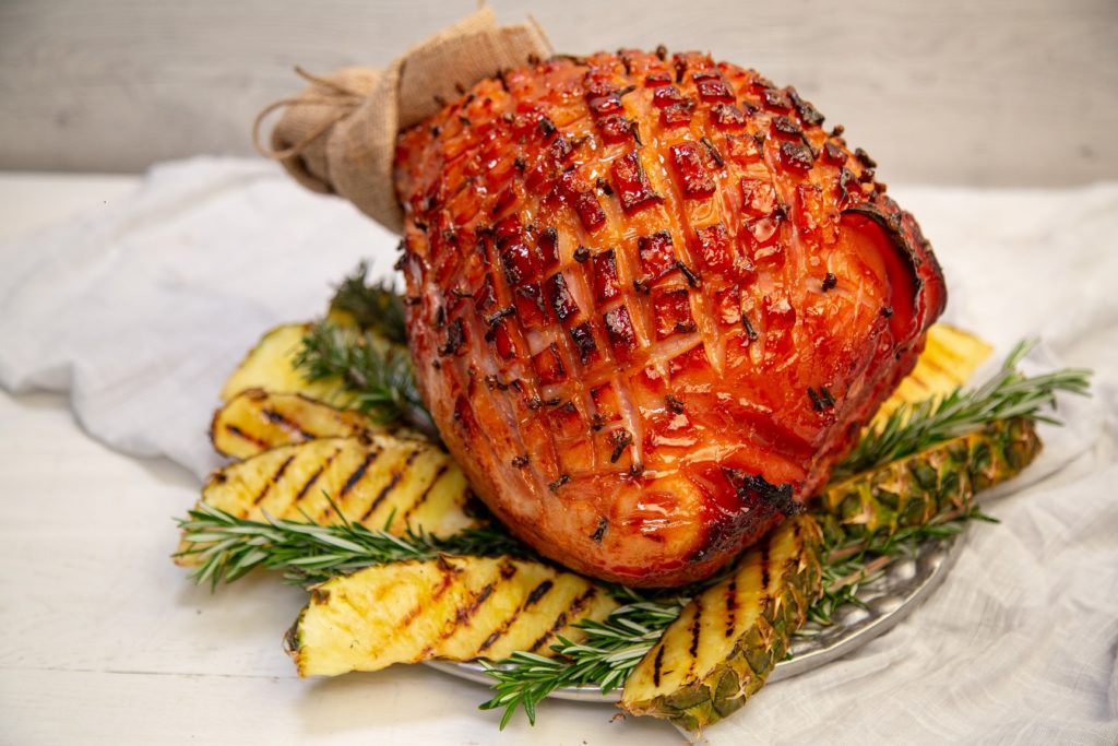 A whole baked ham and grilled pineapple pieces