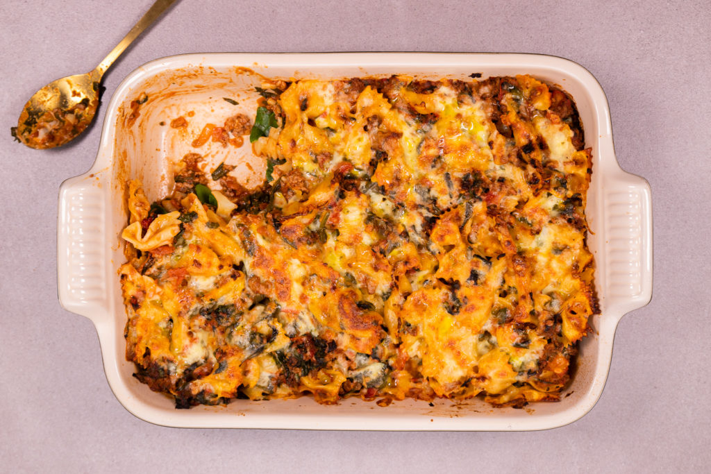 Pasta bake in a rectangle dish with handles with a spoon