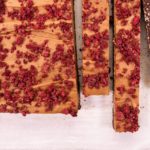 A slab of slices topped with fruit crumbs, three strips sliced.