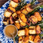 grilled cheese and peach skewers on blue plate and a pot of honey