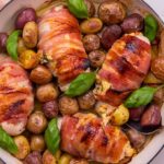cooked bacon wrapped chicken breasts in a casserole pan
