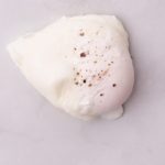 One poached egg on white marble bench top