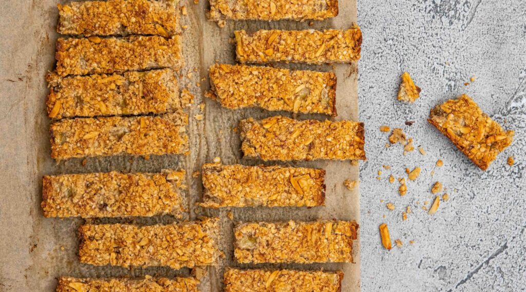 Baked oaty bars on baking paper on marble board