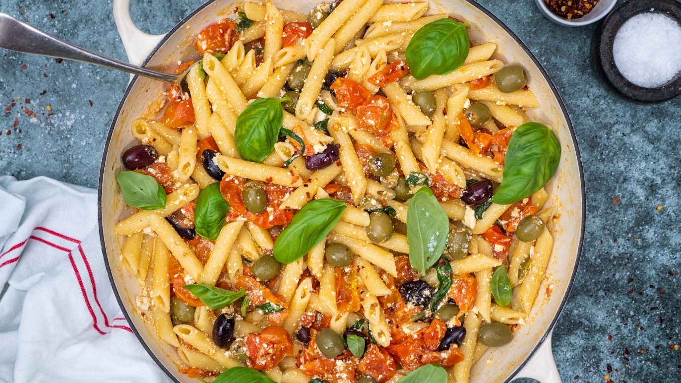 Baked feta and tomato pasta dish with fresh basil