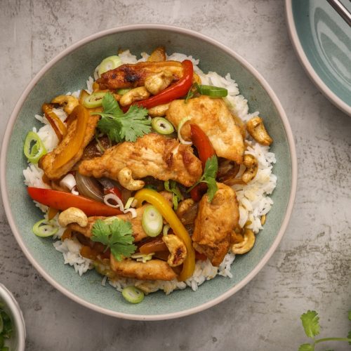 A bowl of chicken and vegetable stir-fry on white rice