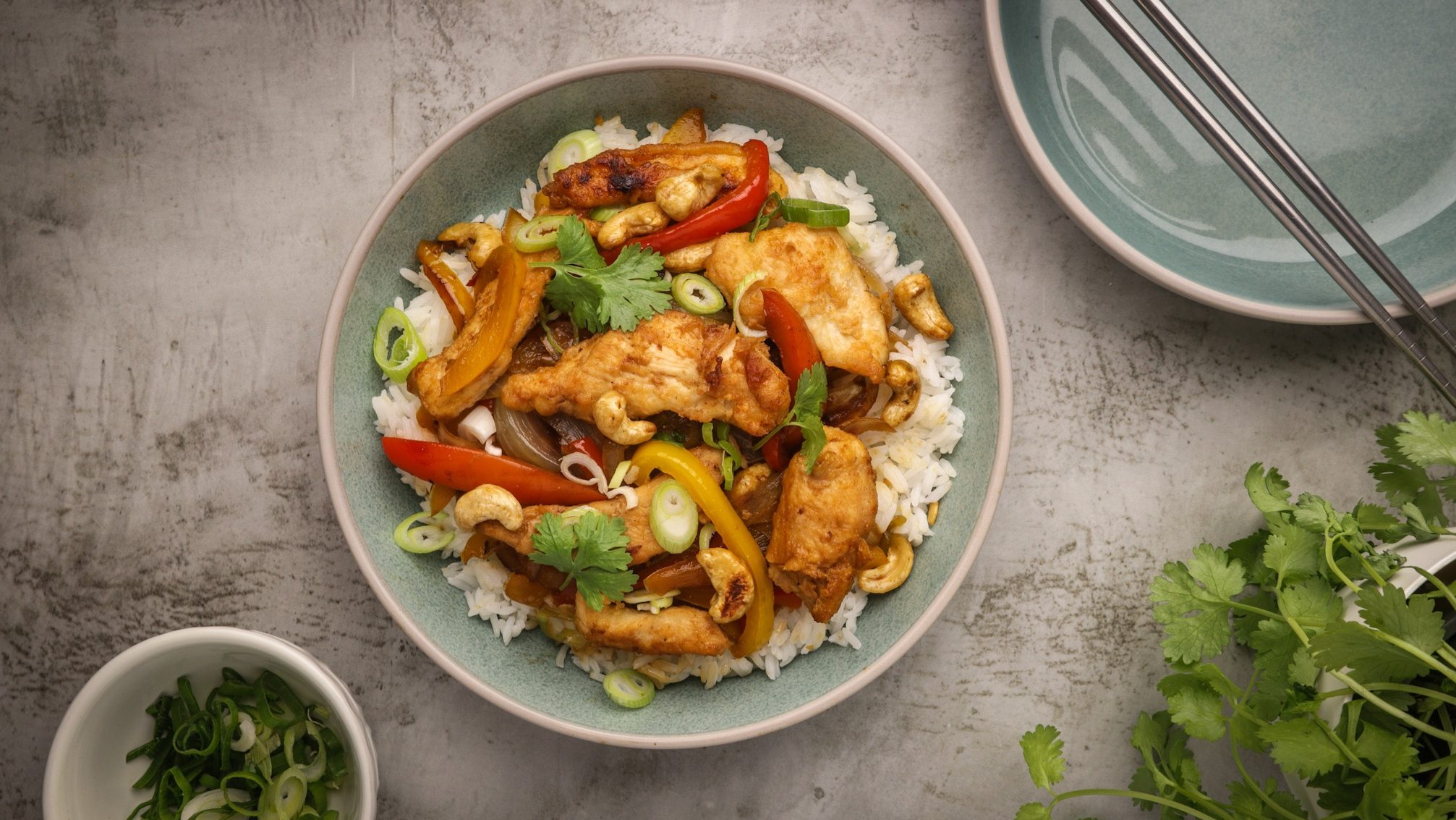 A bowl of chicken and vegetable stir-fry on white rice