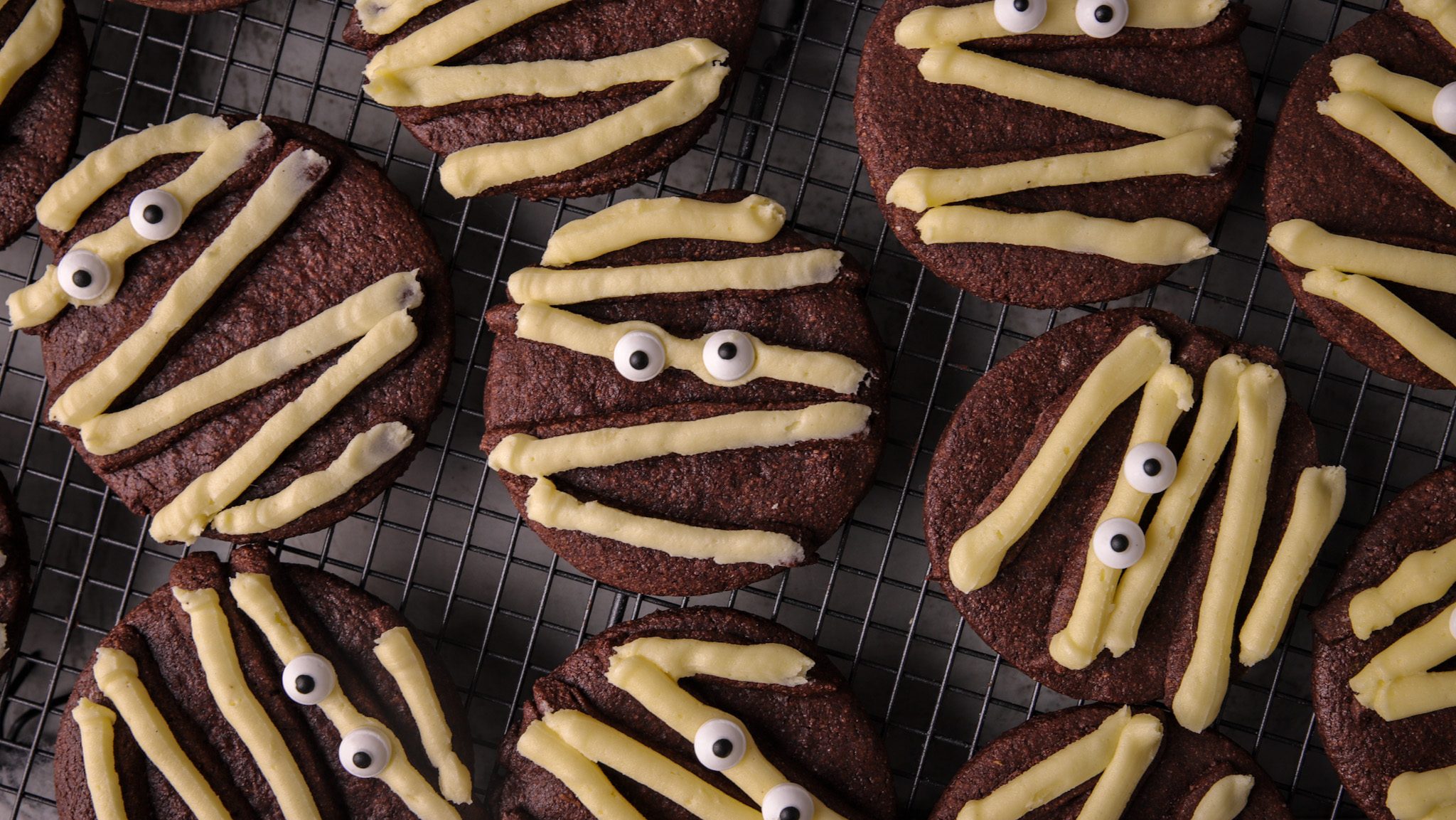 Round chocolate cookies decorated to look like mummy faces.