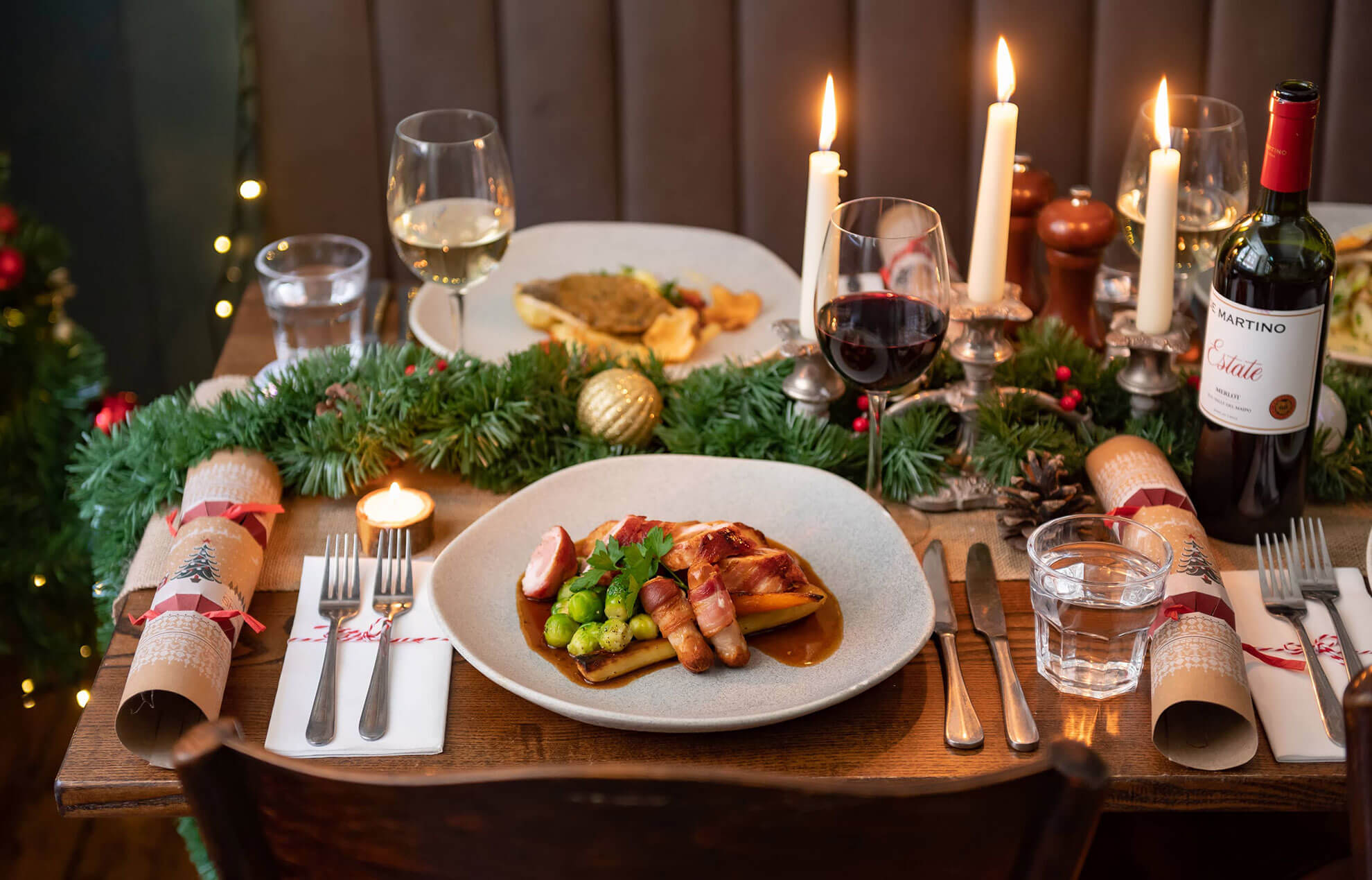 Wooden dining table filled with Christmas-themed food and rustic decor