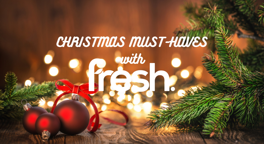 Christmas must-haves with Fresh text with red baubles, fairy lights and pine tree