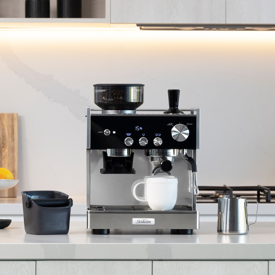 A Sunbeam Orogins Espresso Machine sitting on a kitchen bench against a white background