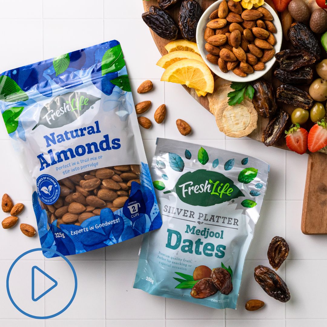 A packet of FreshLIfe Natural Almonds and a packet of FreshLife Pitted Dates next to a grazing platter