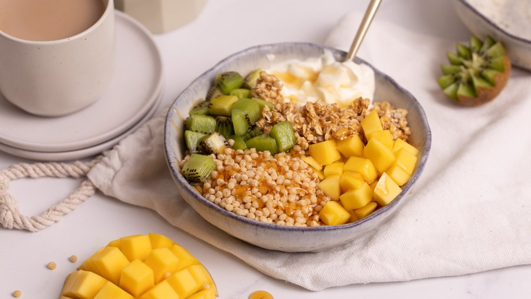 Breakfast cereal in a bowl with yoghurt and fruits.