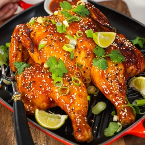Korean BBQ chicken on a black and red dish