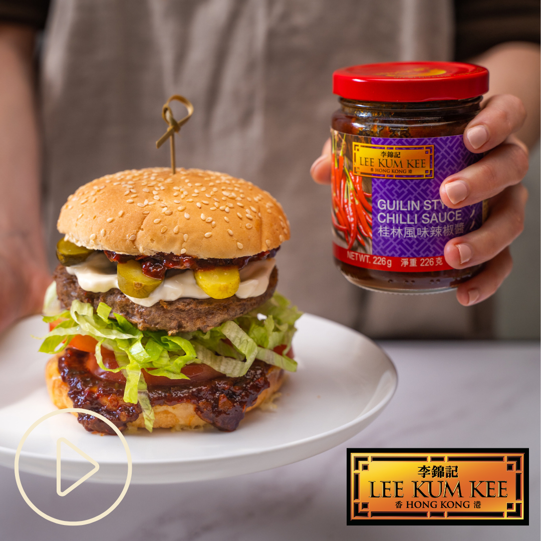 Beef burger on a white plate with a jar of Lee Kum Kee chilli sauce and a play button link