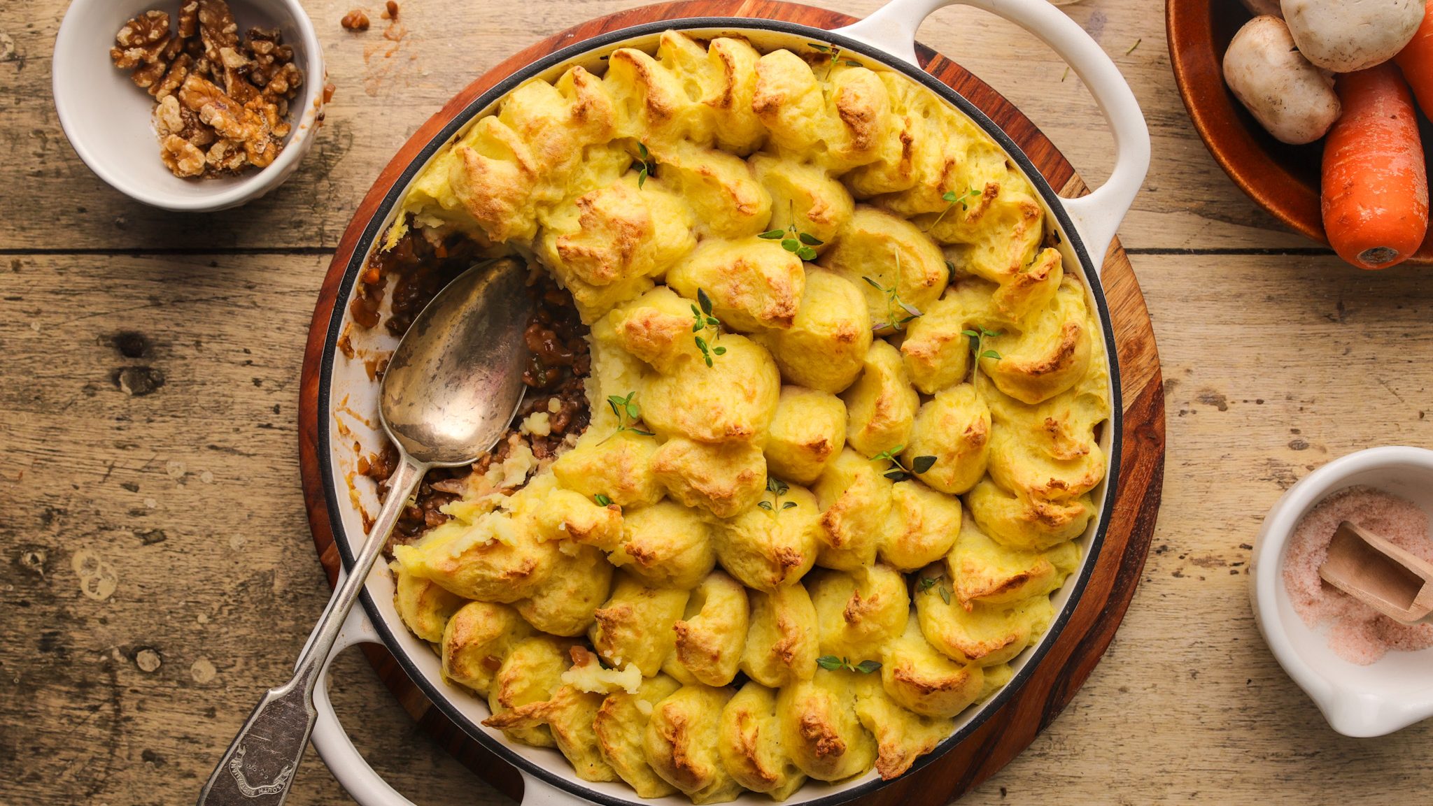 Birdseye view of a shallow casserole filled with mashed potato topped pie with a scoop taken out.