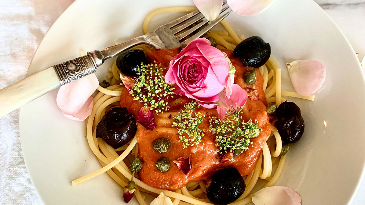 Harissa Pasta with black olives, parsley blossoms and a pink rose