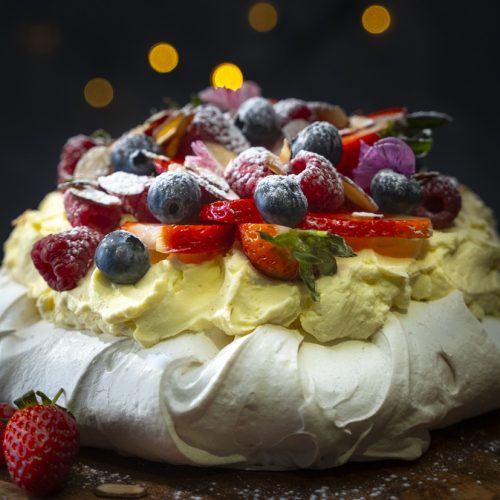A whole pavlova topped with mixed berries.