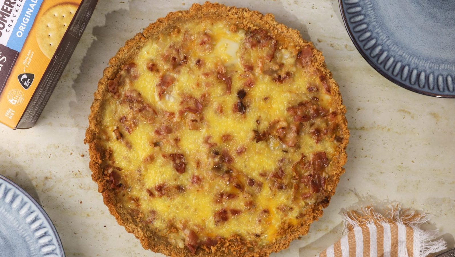 Birds eye view of a whole baked pie with pie crust and yellow filling with ham pieces.