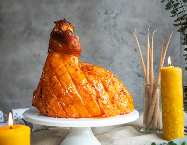 Christmas half ham cooked on the bone, shallow cross-hatch pattern on the fat, covered in a glossy sweet and sour glaze with tomato, mustard, vinegar, Worcestershire sauce, honey and citrus base.