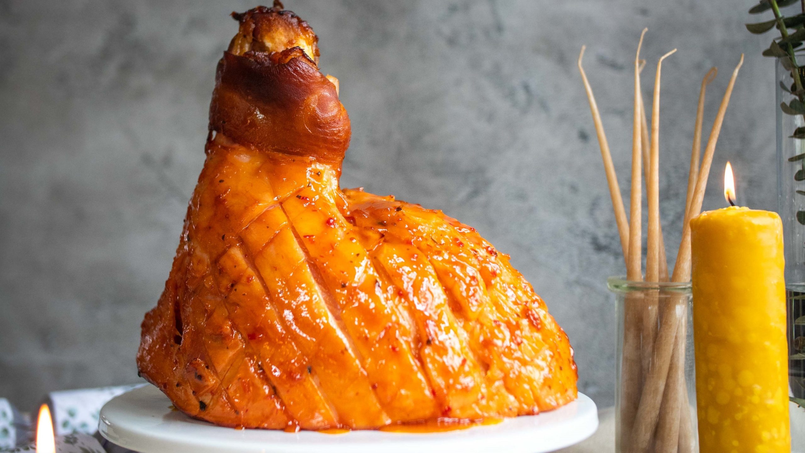 Christmas half ham cooked on the bone, shallow cross-hatch pattern on the fat, covered in a glossy sweet and sour glaze with tomato, mustard, vinegar, Worcestershire sauce, honey and citrus base.