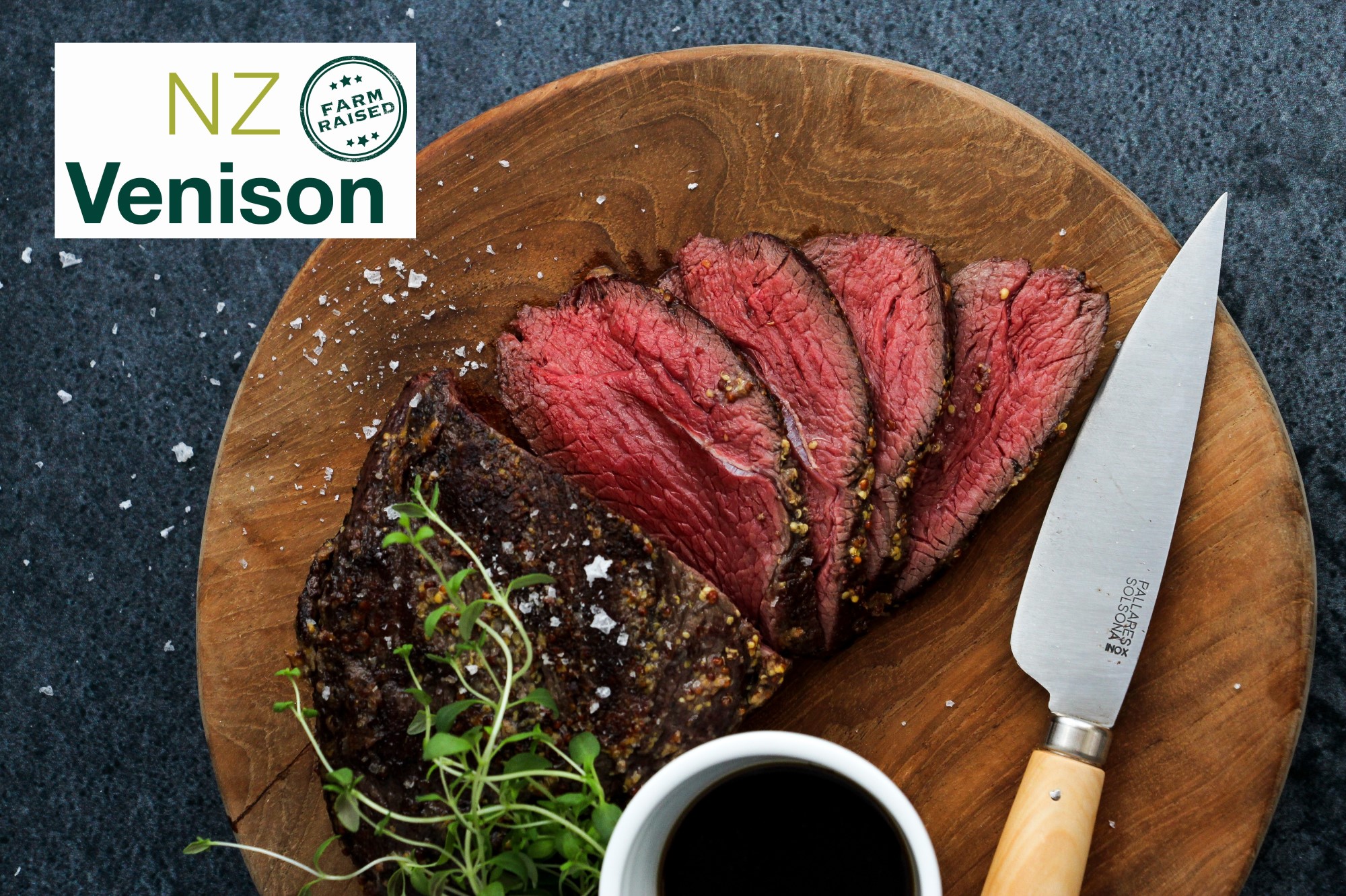 NZ Venison logo over a piece of cooked venison steak on a wooden board
