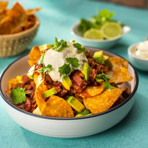 Venison Nachos in a bowl with sides.