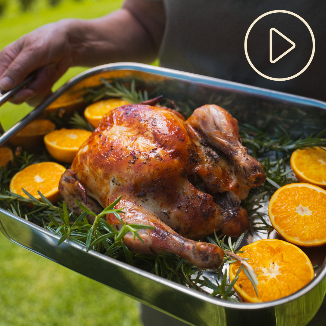 A roated Waitoa free range chicken in a tray with sliced oranges
