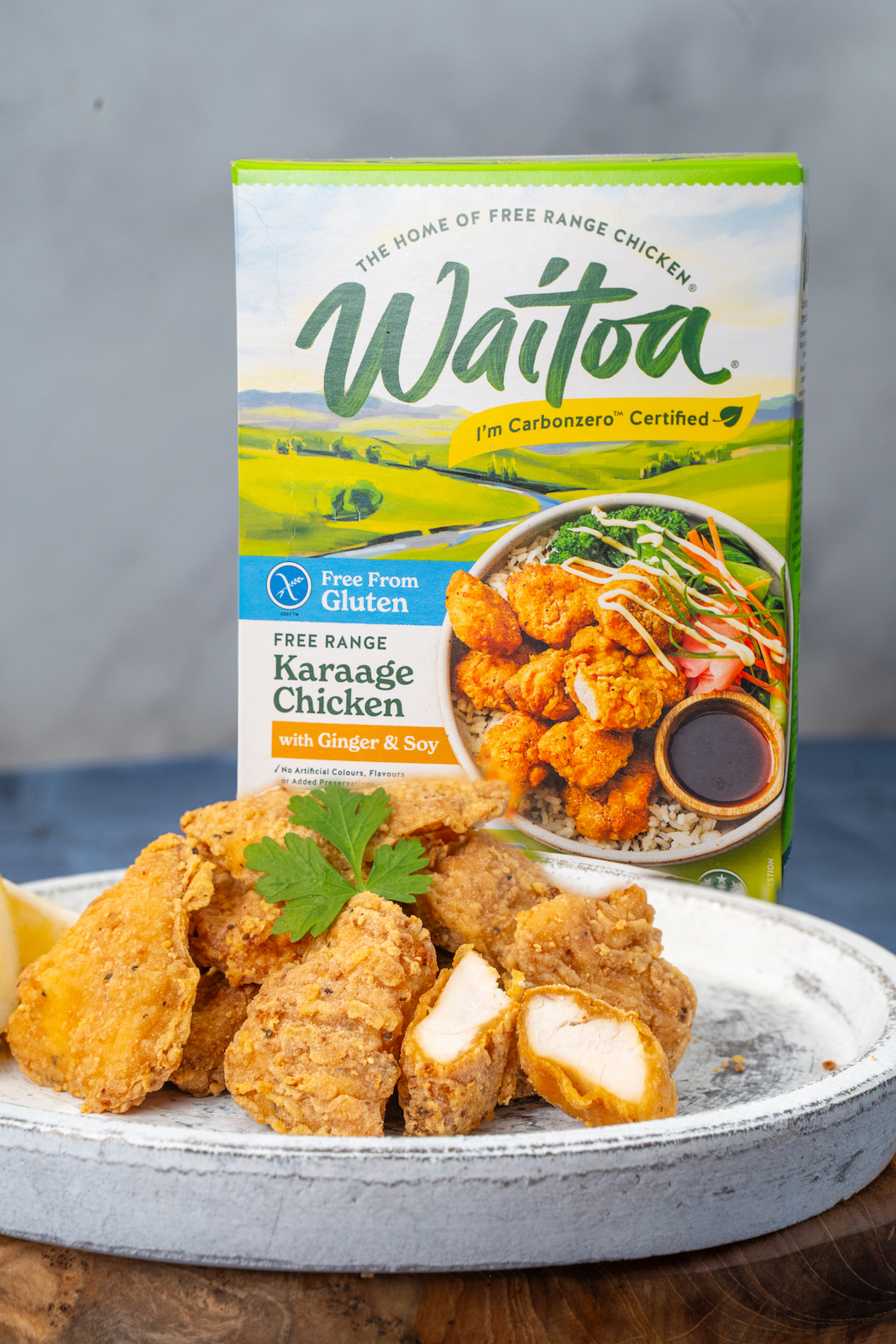 A packet of Waitoa Karaage Chicken with a plate of karaage chicken pieces in the foreground