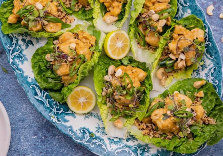 Cooked chicken and rice on lettuce leaves on a large blue platter