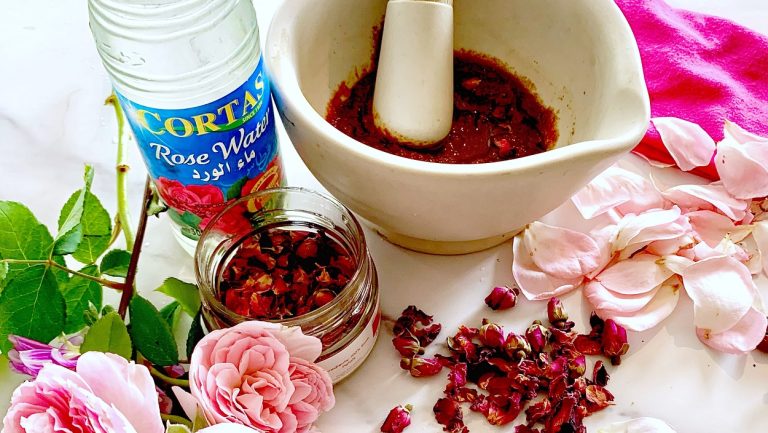 Rose harissa with mortar and pestle and fresh pink roses